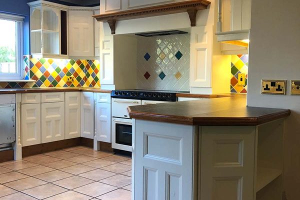 white sprayed kitchen cupboards with eyecatching tiles