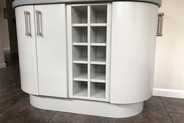 White kitchen island with wine shelves
